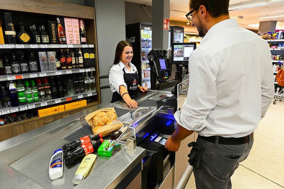 Im Beckesepp-Supermarkt in Haslach scannt die Verkäuferin die Waren nur noch ein und nennt den Zahlbetrag. Sein Geld steckt oder schüttet der Kunde dann in einen Kassenautomaten, der blau aufblinkt. (Foto: Ingo Schneider)